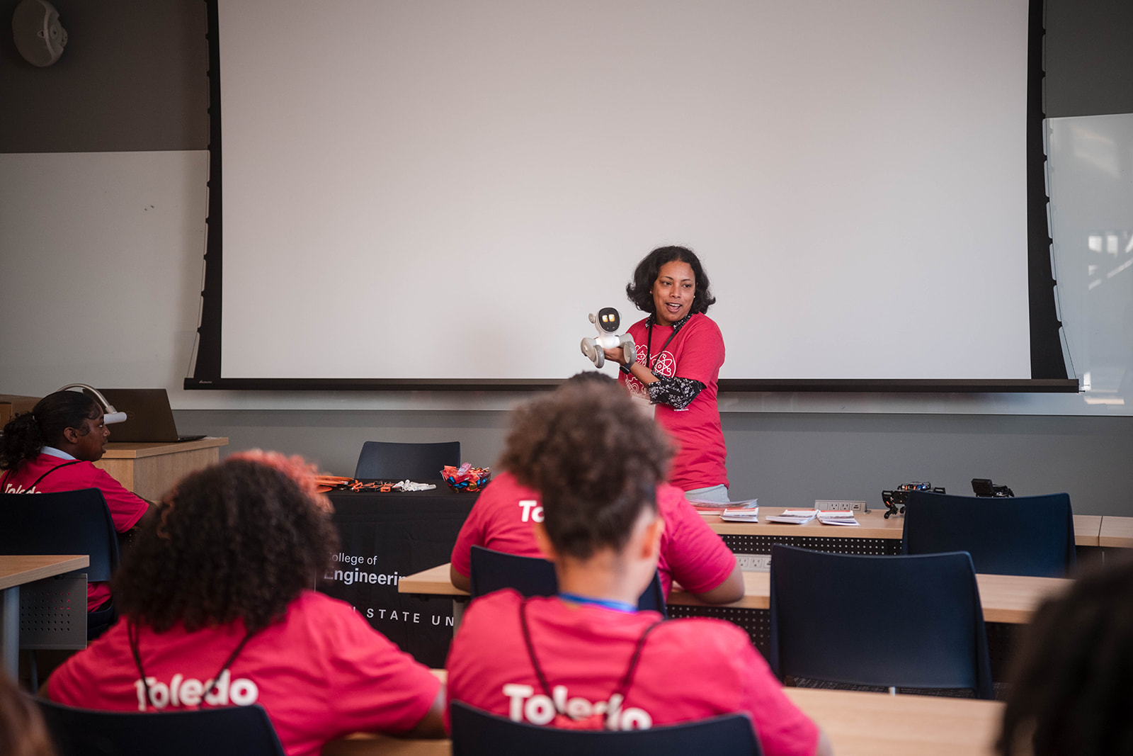 Instructor demonstrating robotics to a group of students.